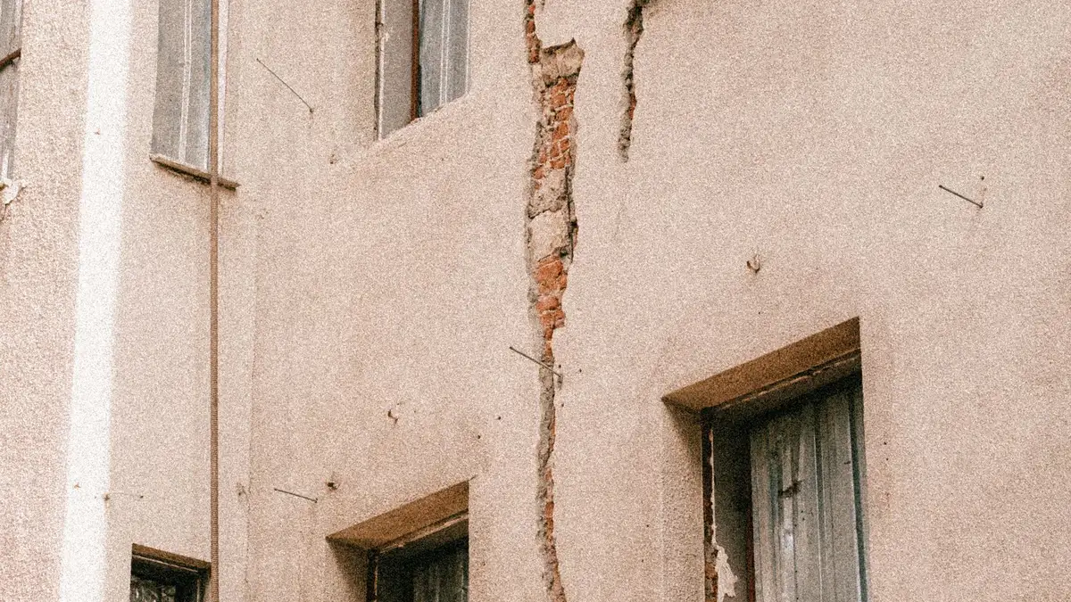 Grietas en el revoco de una fachada alrededor de las ventanas