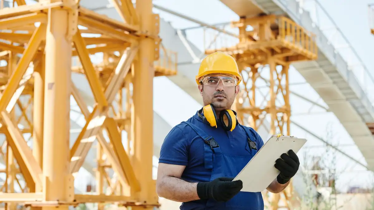 Técnico con casco revisando un informe de inspección en obra