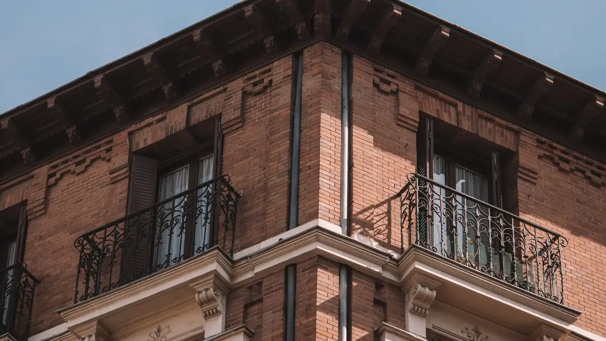 Edificio residencial de ladrillo en Madrid con balcones y ventanas alineados en la fachada