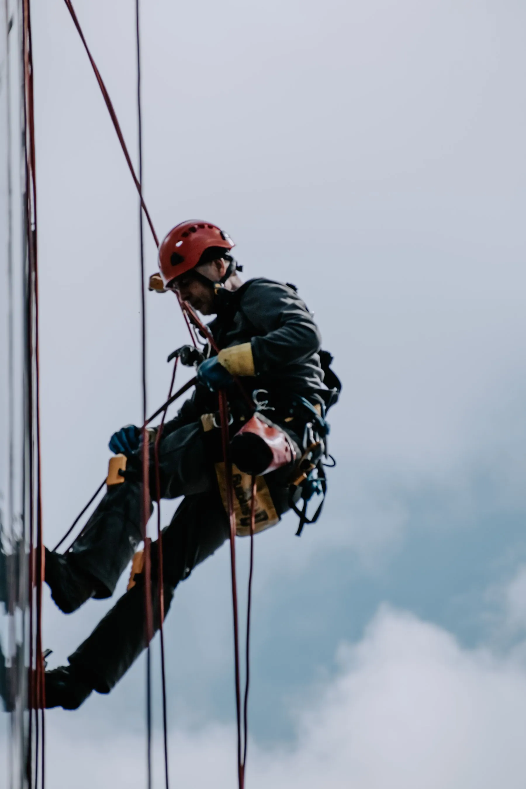 Técnico de trabajos verticales con casco descendiendo por una fachada